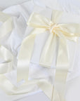 Cutie albă elegantă legată cu panglică satin ivory lată, fundă sofisticată pentru cadouri, nunți și evenimente premium – Diandra Events