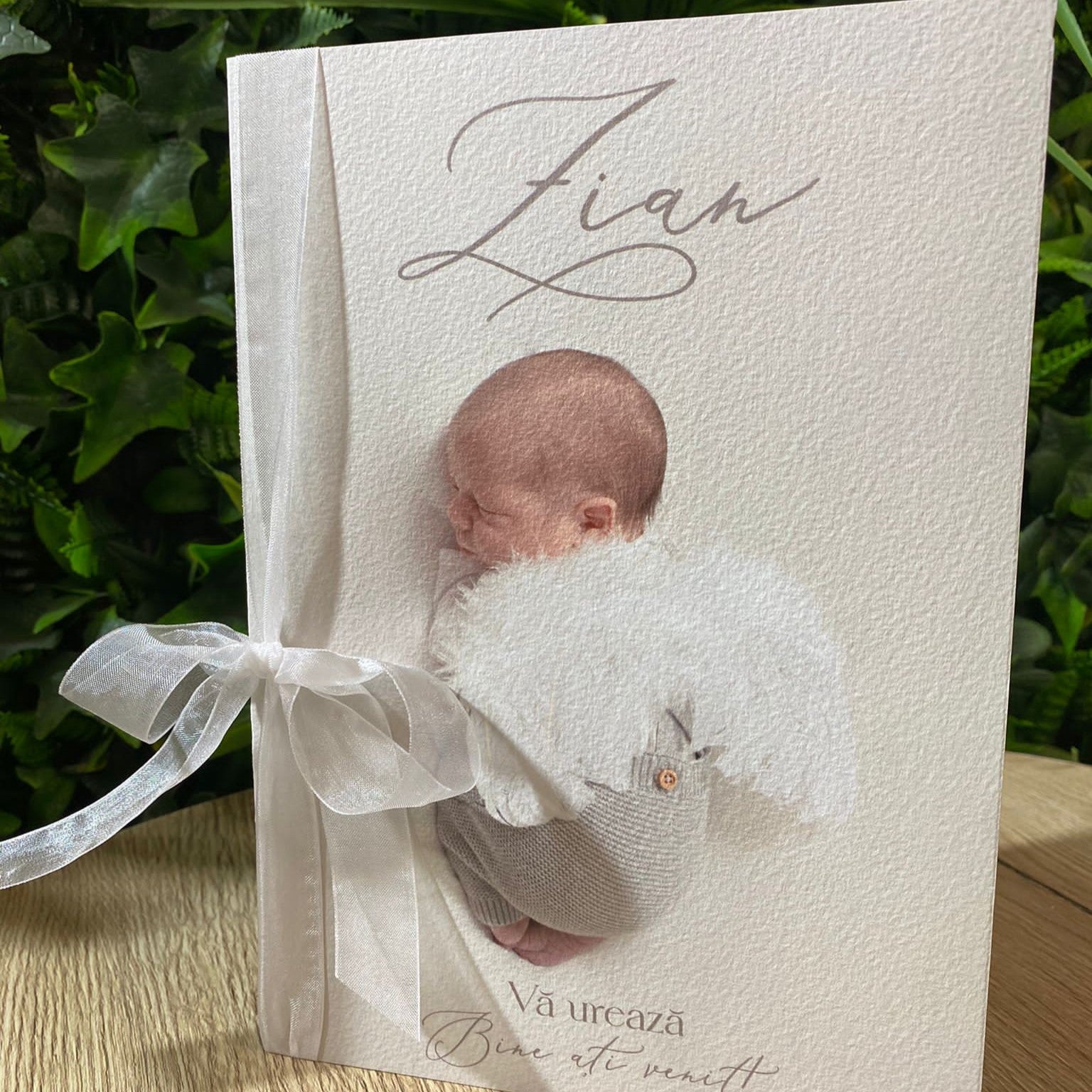 Meniu botez personalizabil tip carte, detaliu prim-plan cu fotografie bebeluș îmbrăcat în îngeraș și fundă albă – Diandra Events