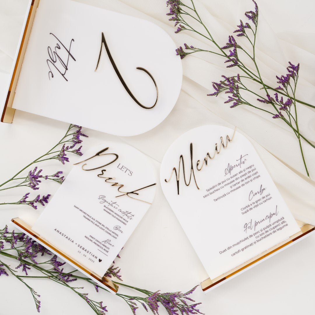 Număr de masă, meniu și plăcuțe cu nume din acril alb cu detalii aurii, design lux, realizate de Diandra Events pentru decor elegant de nuntă