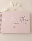 Guest book personalizat folio cu text „Our Love Story”, copertă roz și spirală aurie, ideal pentru nuntă sau aniversare realizat de Diandra Events