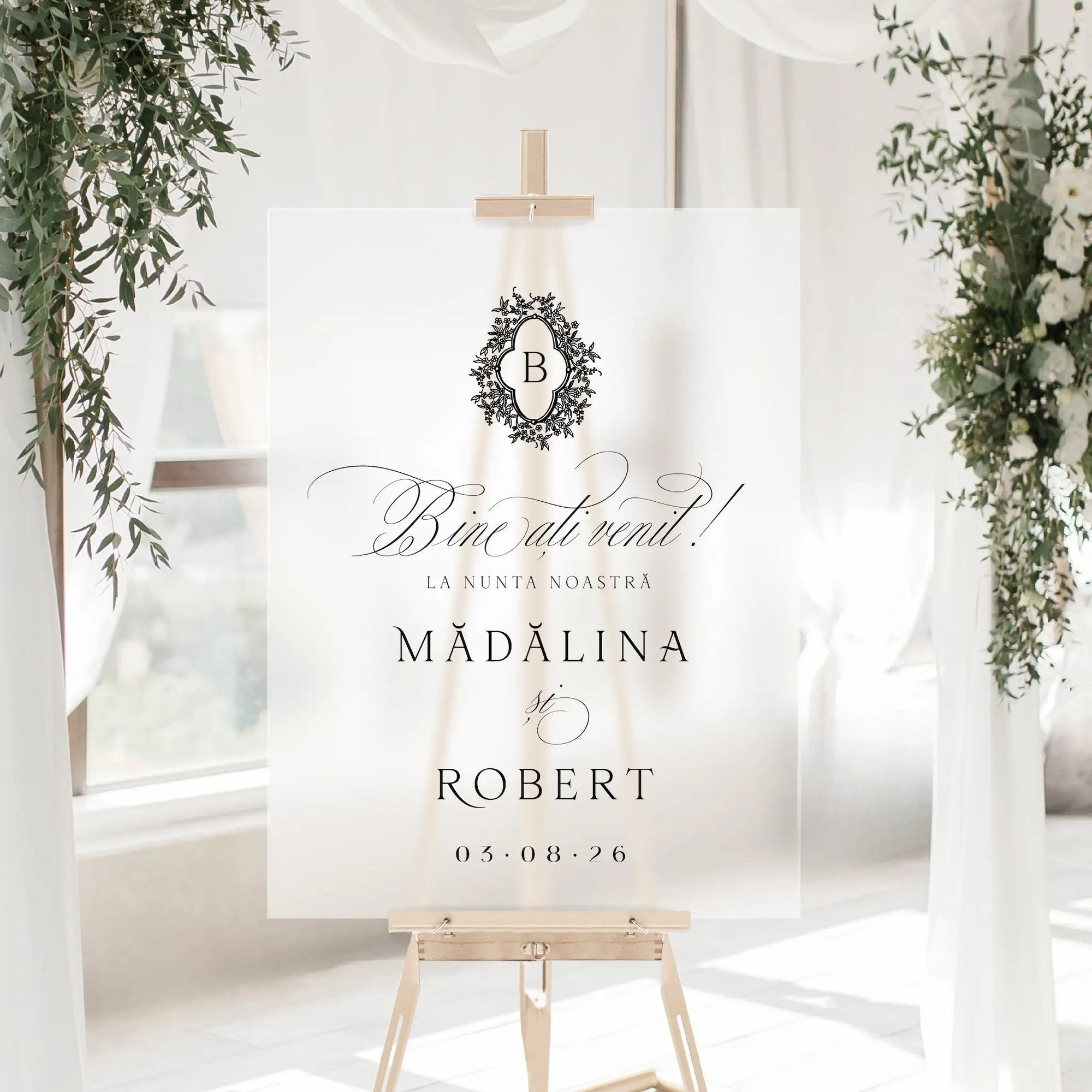 Panou bun venit nuntă acrilic plexiglas frosted, semn-bun-venit minimalist, decorat cu frunze verzi și flori albe, lumină naturală, Diandra Events
