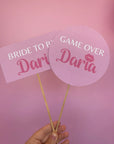 Party pops personalizate pentru petrecerea burlăcițelor, cu texte „Bride to Be” și „Game Over”, accesorii amuzante pentru distracție