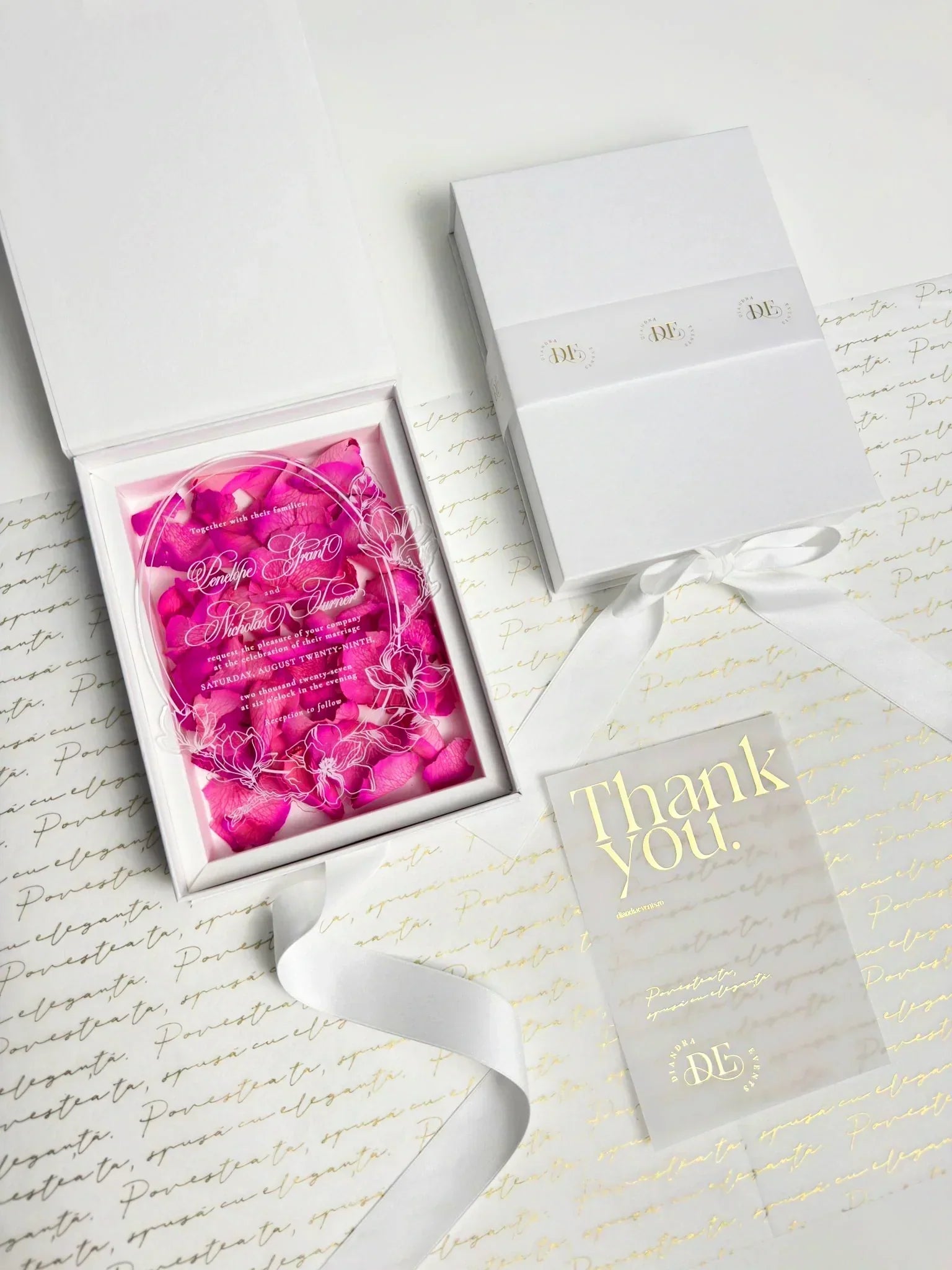 Elegant plexiglass wedding invitation in white luxury box with preserved rose petals