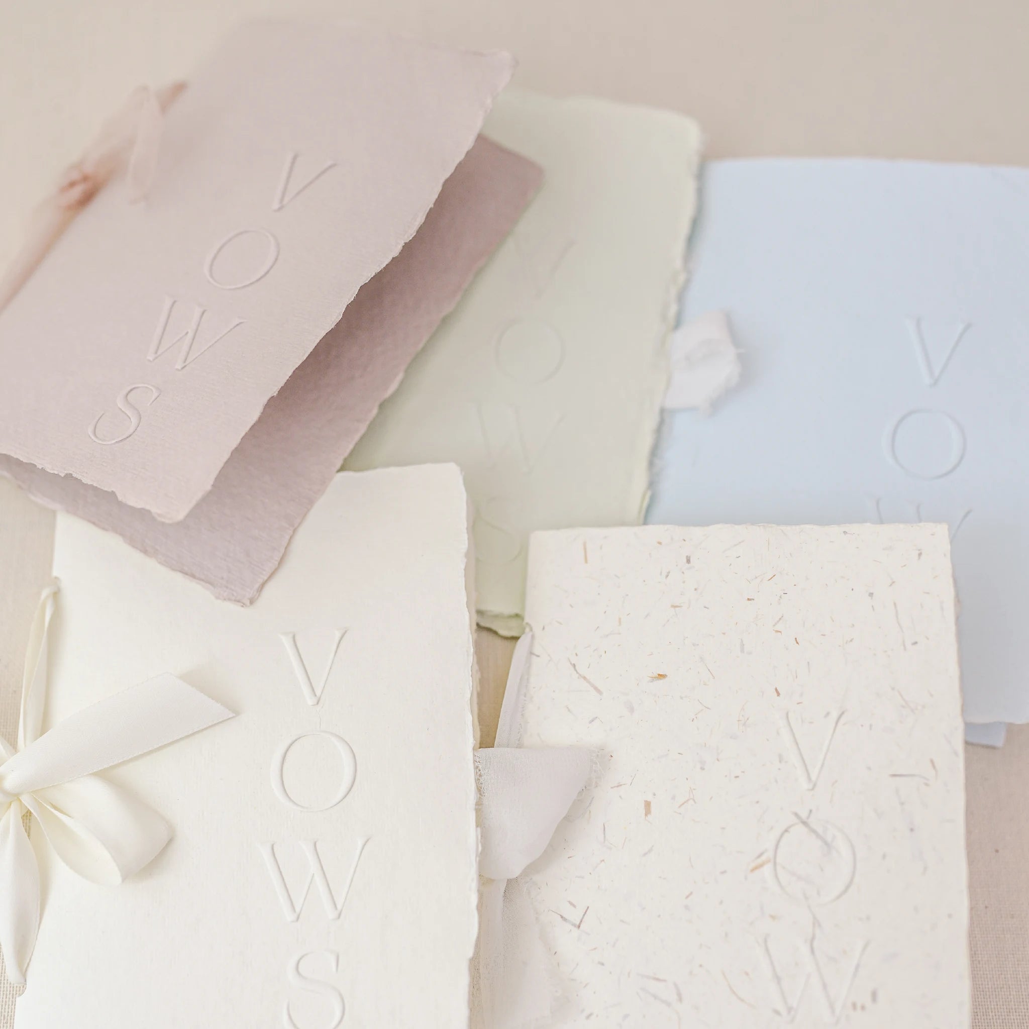 Set carte jurăminte  Vows din hârtie manuală embosată cu panglică de mătase, culori roz pudră, verde pastel, alb, alb natural texturat și albastru deschis, papetărie handmade fine art realizată de Diandra Events pentru nuntă elegantă